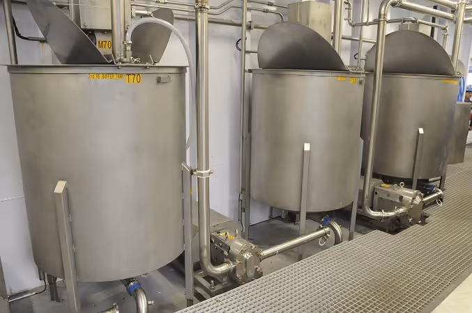 Three stainless steel wash tanks with piping and valves.