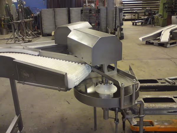 Stainless steel fish spinner machine for transferring fillets to inspection conveyor.