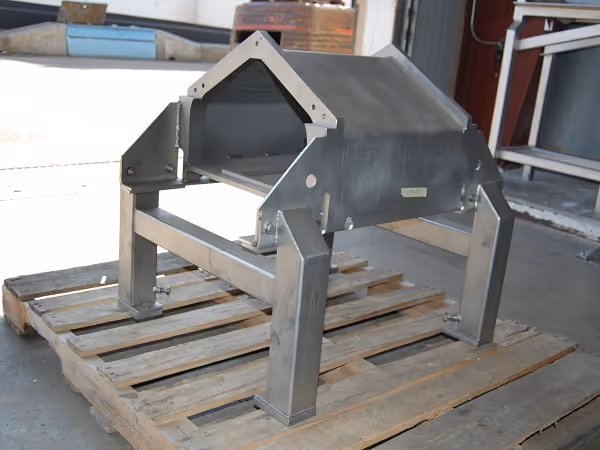 A stainless-steel foundation frame for a Baader or Toyo processing machine, mounted on a wooden pallet in a workshop.