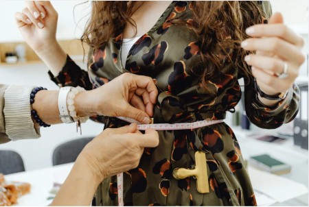 image of a tailor with a costume in the background