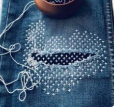 image of a tailor deep in thought while stitching