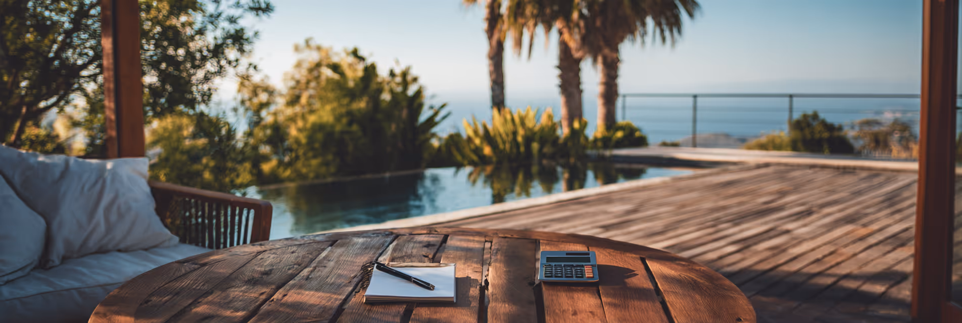 Sunglasses and a calculator on a table by a pool