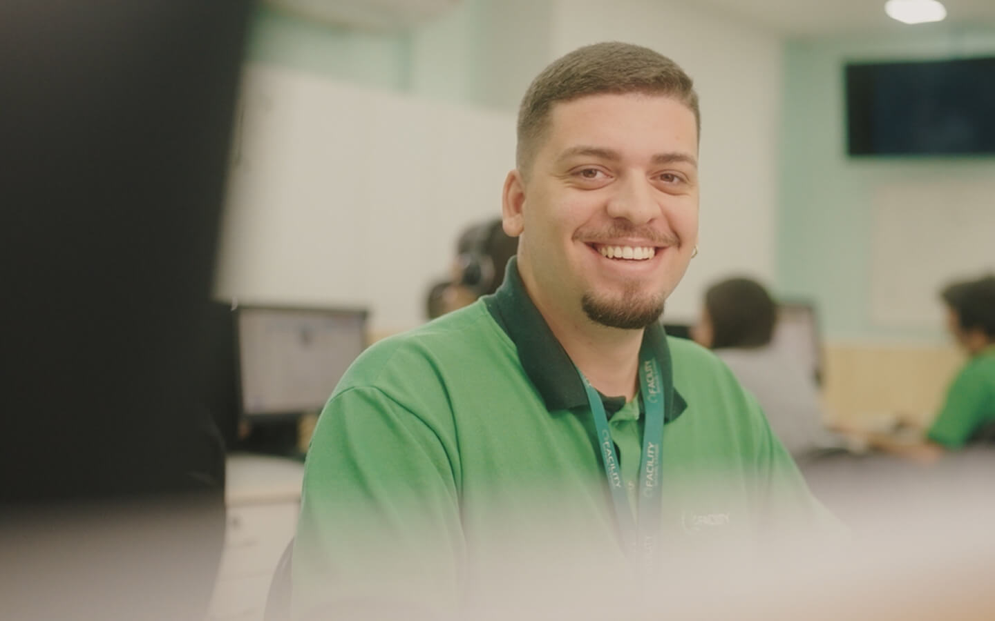 Funcionários da Facility sorrindo com o boneco da Facility