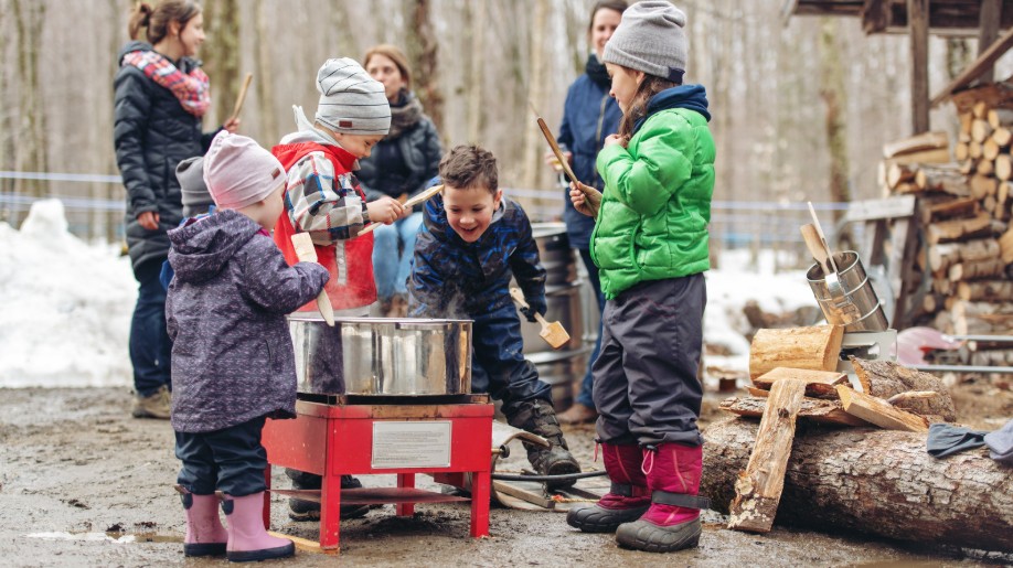 Children and families visiting a sugarhouse for maple syrup tasting in New Hampshire