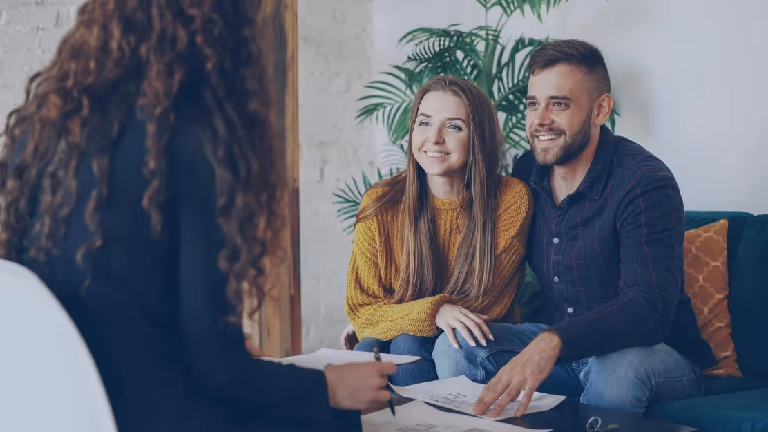 Homebuyer reviewing an offer strategy with a real estate agent in Manchester or Nashua, New Hampshire.