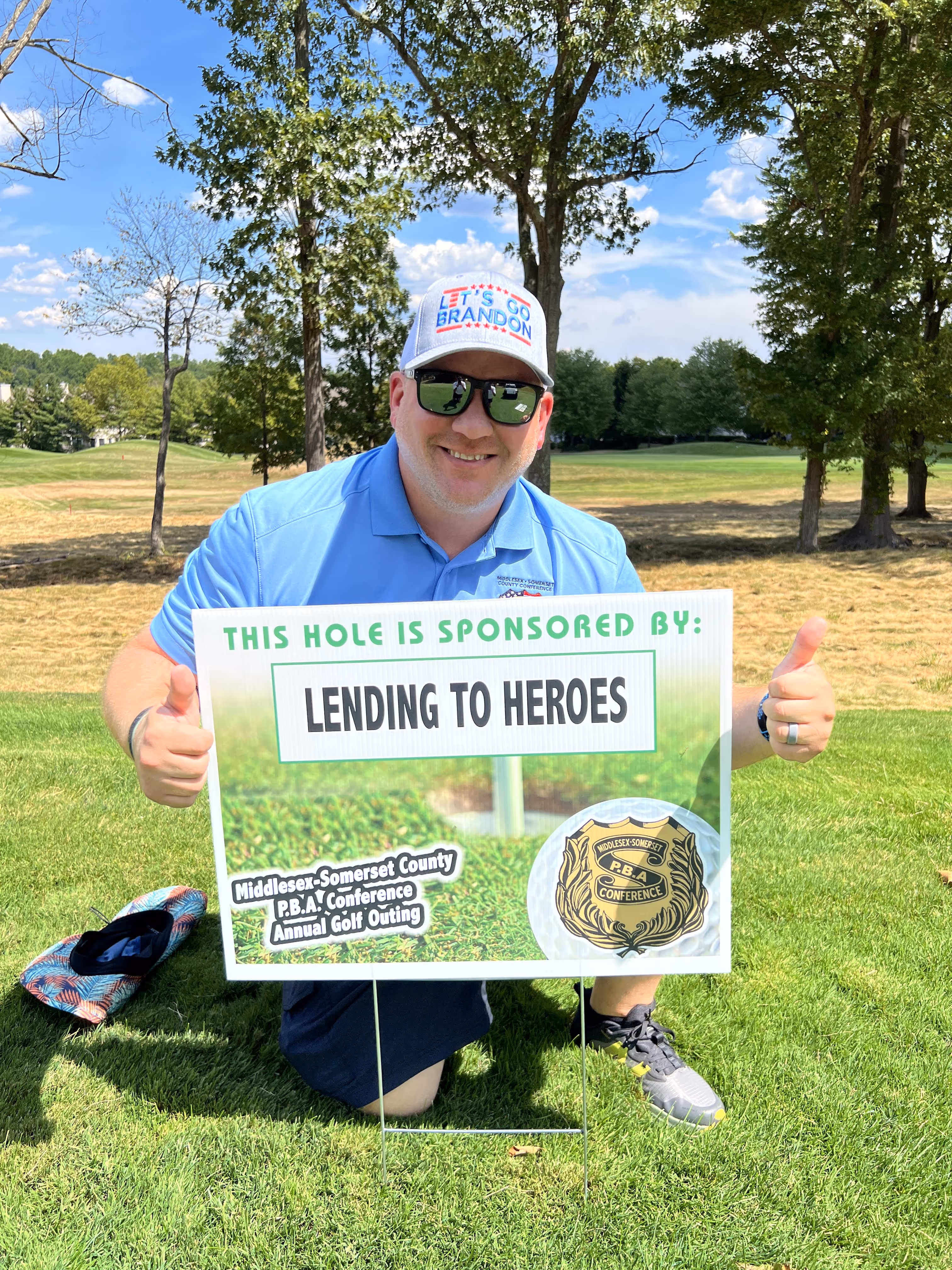 Middlesex/Somerset County Conference PBA Officer photo holding Golf event sponsor flyer