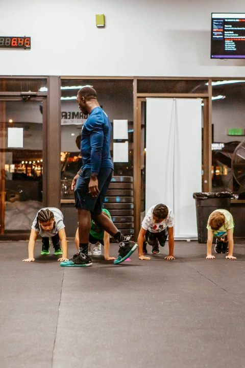 A group of children performing push-ups in a gym at Game Ready Fitness in Thornton, CO.