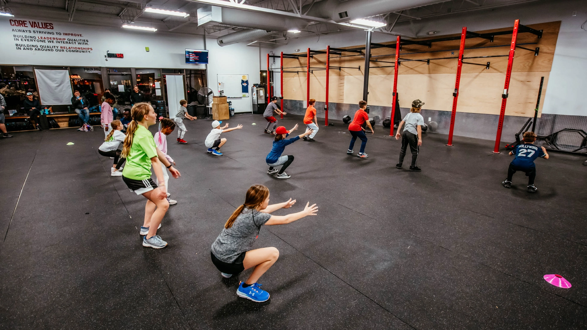 CrossFit gym interior at Game Ready Fitness in Thornton, CO, showcasing workout equipment and athletes in action.