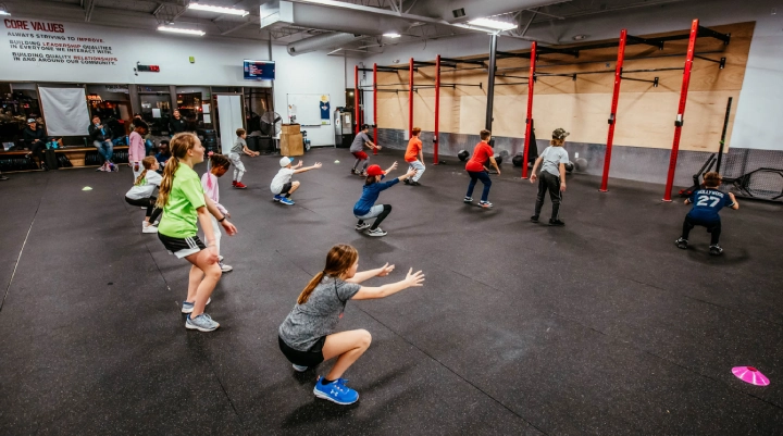 CrossFit gym interior at Game Ready Fitness in Thornton, CO, showcasing workout equipment and athletes in action.