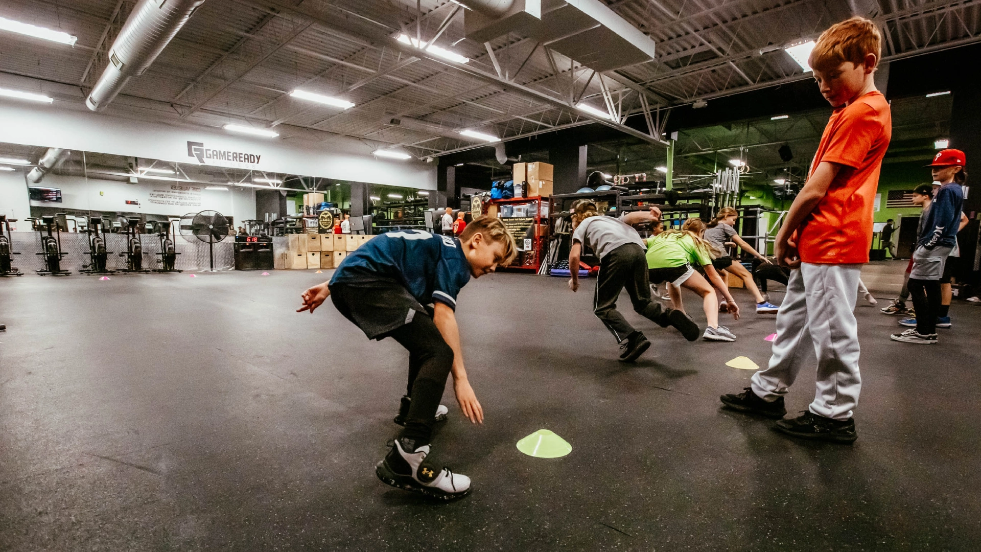 Kids playing with a ball in a gym at Game Ready Fitness in Thornton, CO, enjoying active play and teamwork.