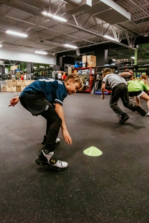Kids playing with a ball in a gym at Game Ready Fitness in Thornton, CO, enjoying active play and teamwork.