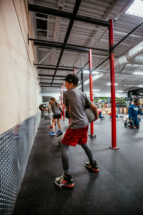 A young boy plays with a ball in the gym at Game Ready Fitness in Thornton, CO.