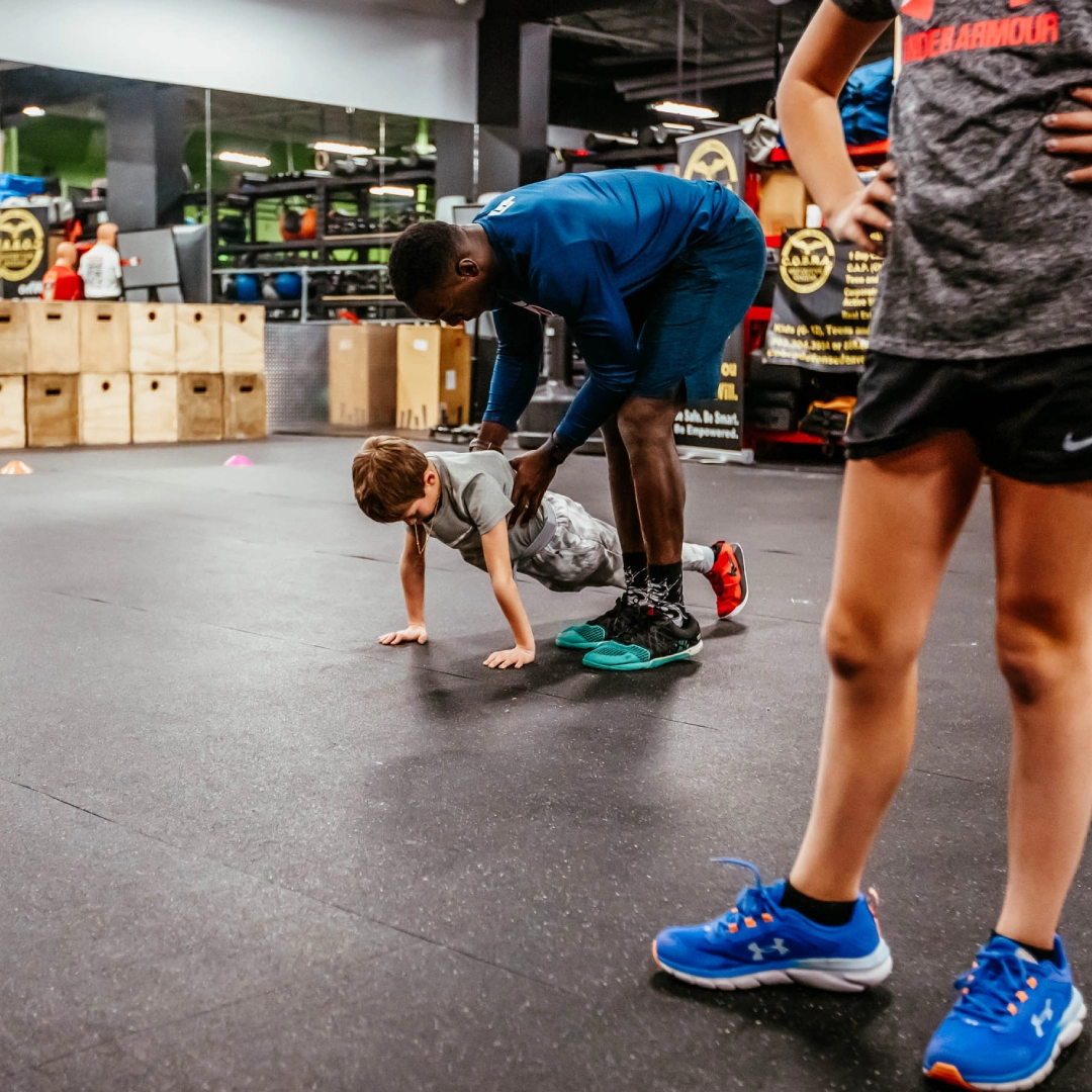 A man and a boy perform push-ups together in the Game Ready Fitness gym in Thornton, CO.