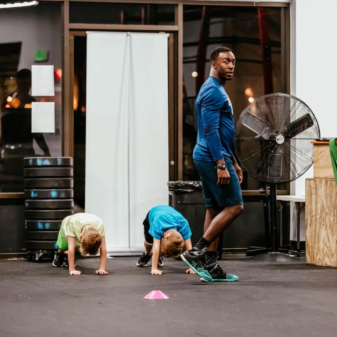 A man instructs children on a CrossFit workout at Game Ready Fitness in Thornton, CO.