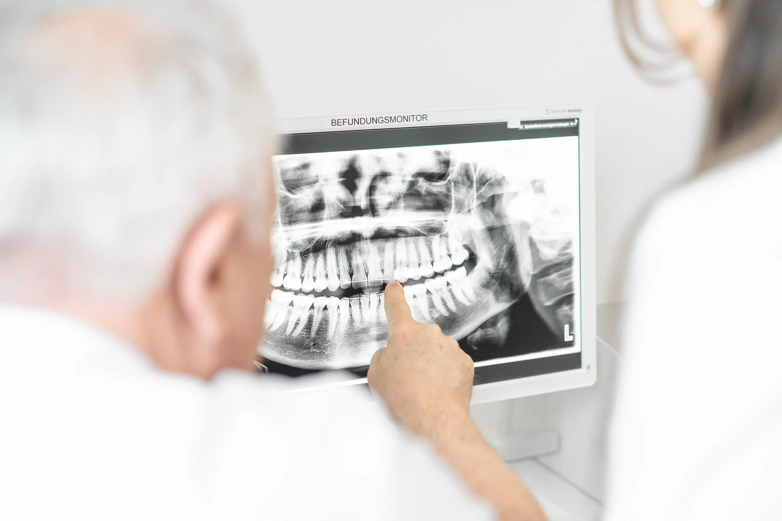 Zahnärzte deuten auf einen Röntgenschirm