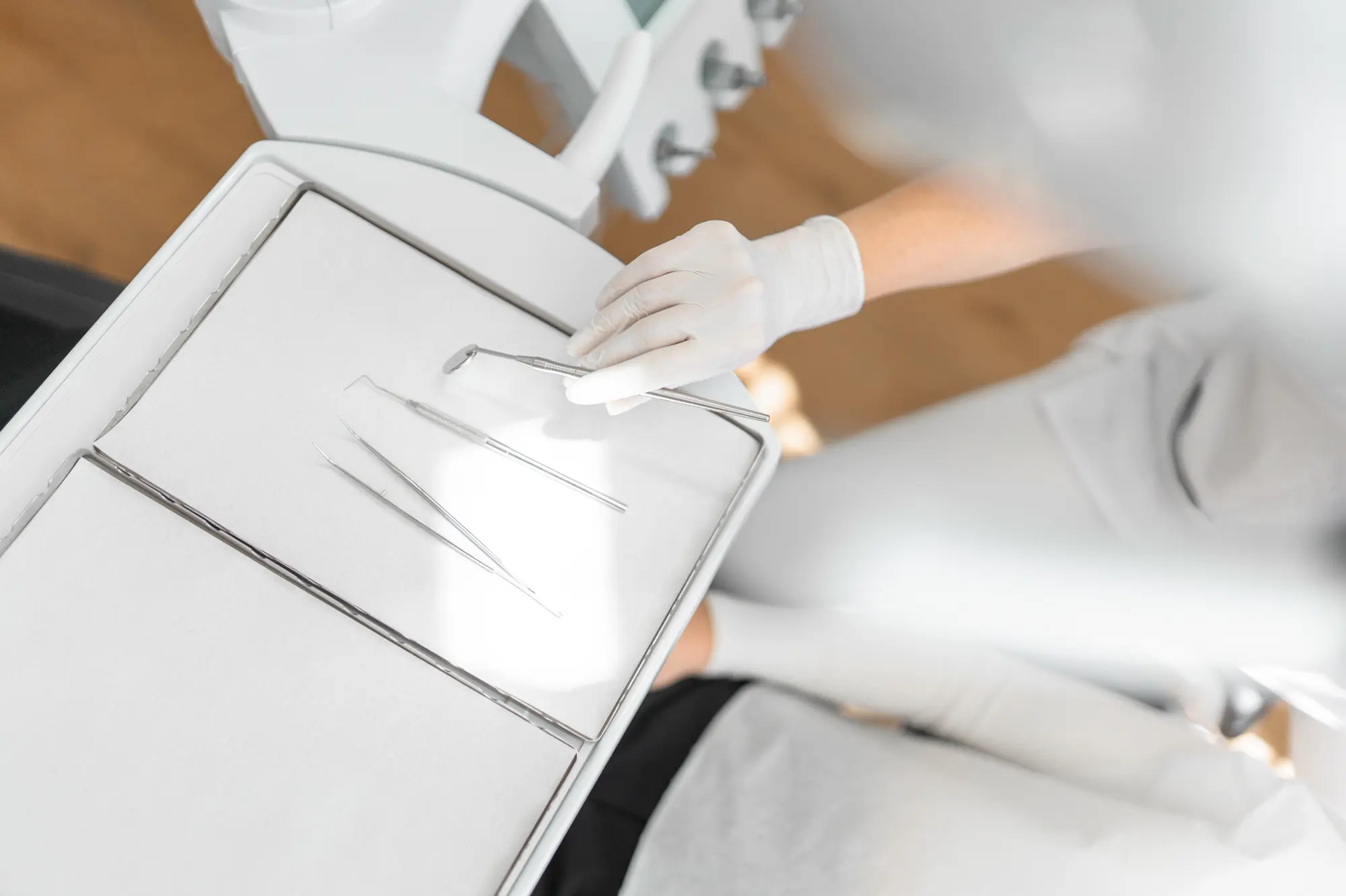 Zahnärztin nimmt Zahnutensilien in die Hand