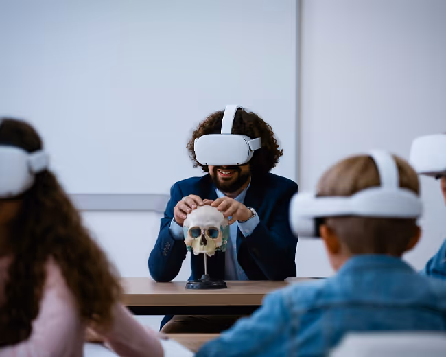 A class of students and their teacher wearing headsets discussing the anatomy of the human skull.