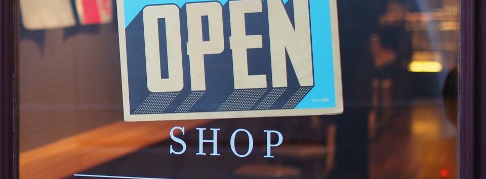 Open sign hanging in a local shop window