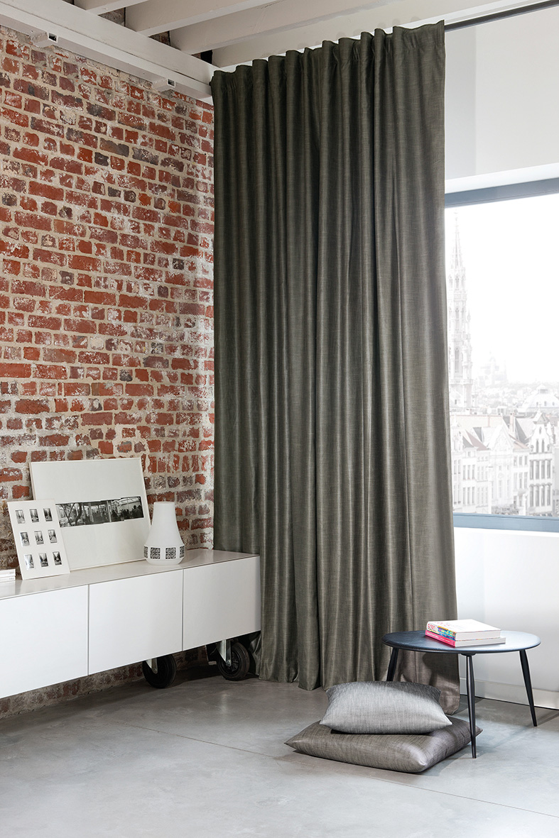 floor length curtains next to a brick wall in an apartment