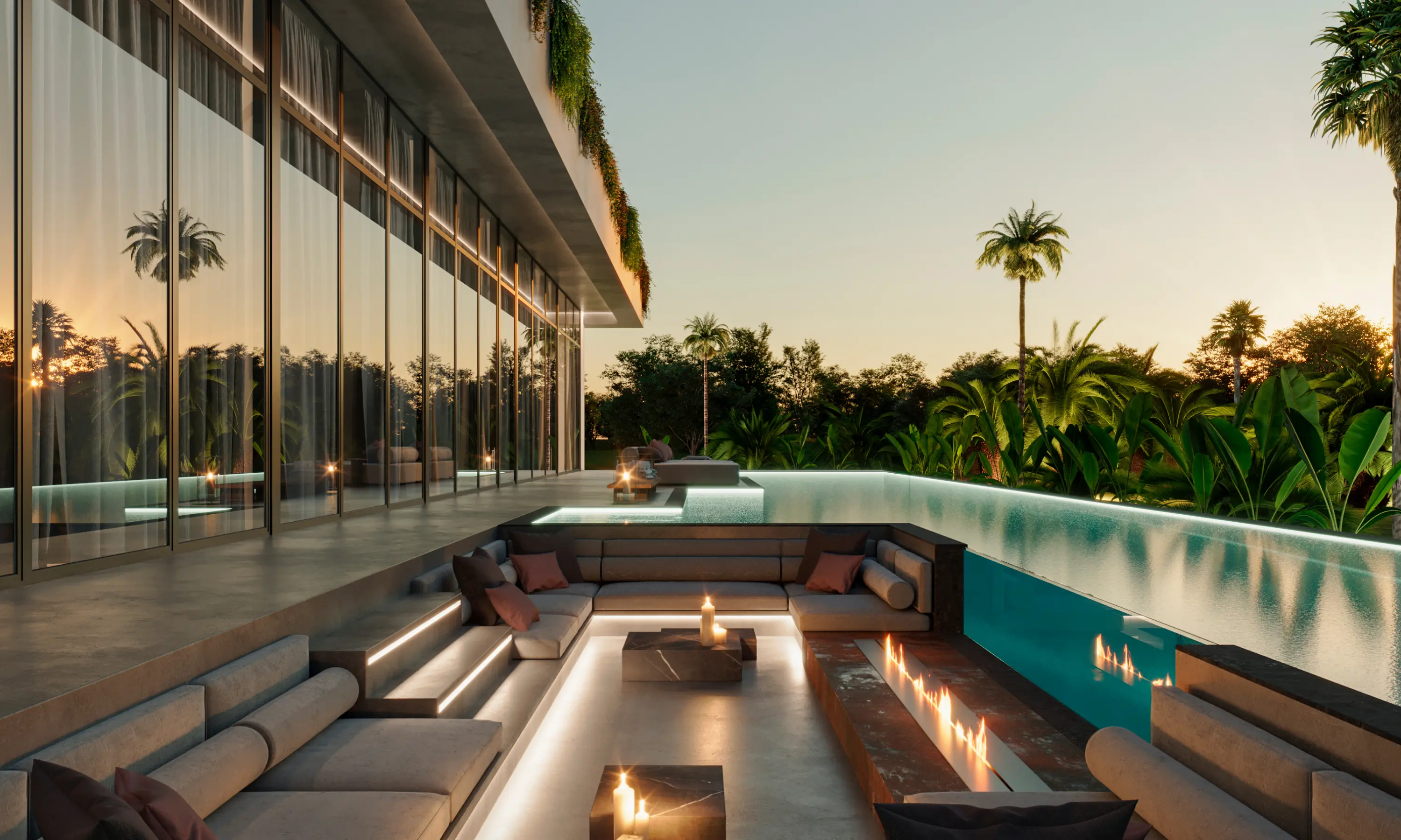 Modern outdoor lounge area with sunken seating, fire feature, infinity pool, and tropical plants at sunset.