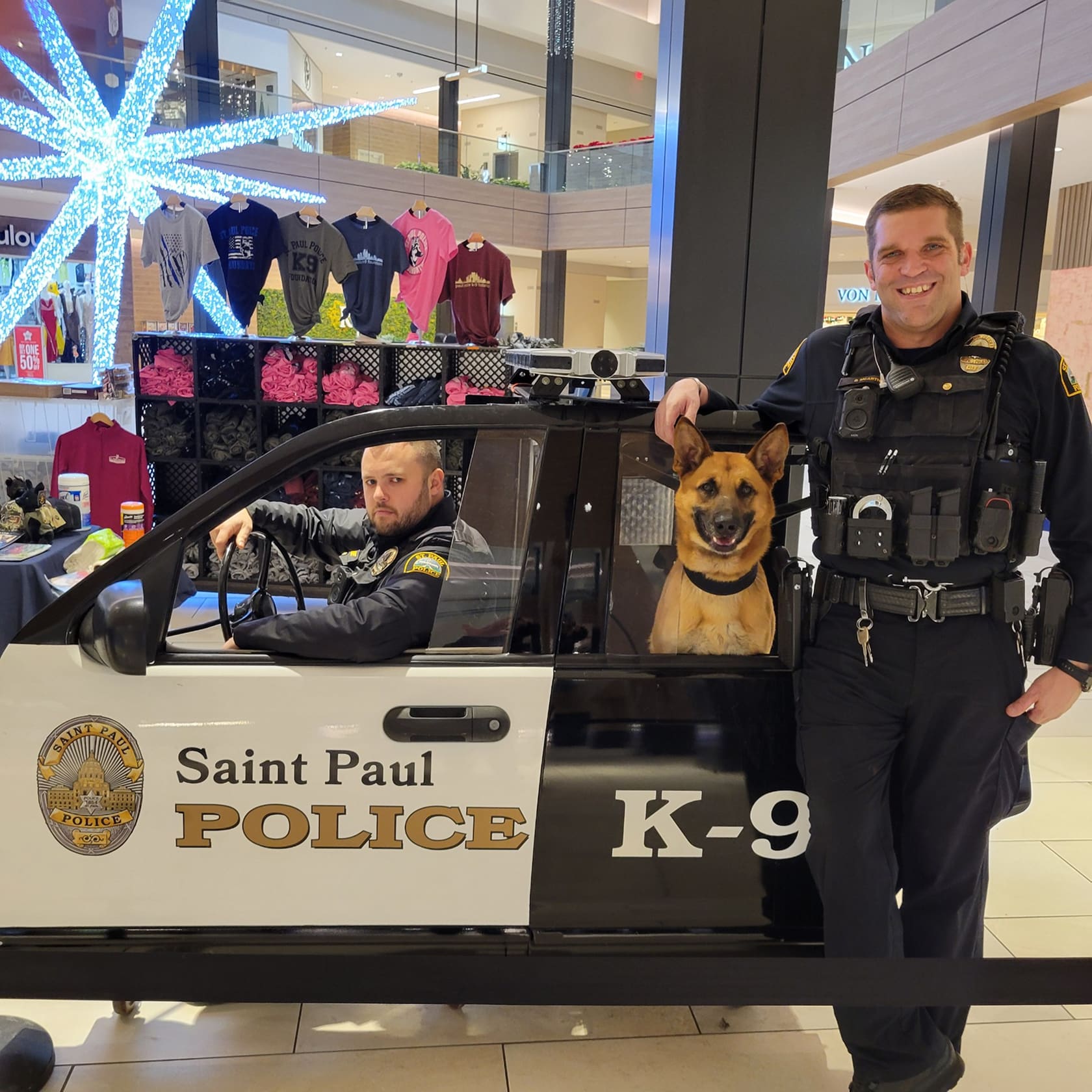 Two Saint Paul police officers with a police dog in a K-9 unit vehicle inside a mall.