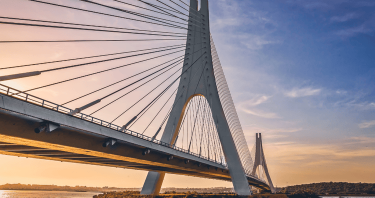 modern cable-stayed bridge extending over a river at sunset, illustrating advanced civil engineering, transport connectivity, and large-scale infrastructure development. industries