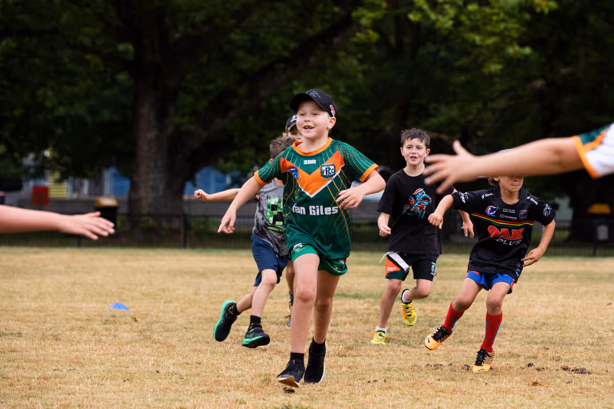 Young kids playing group sport in a park.