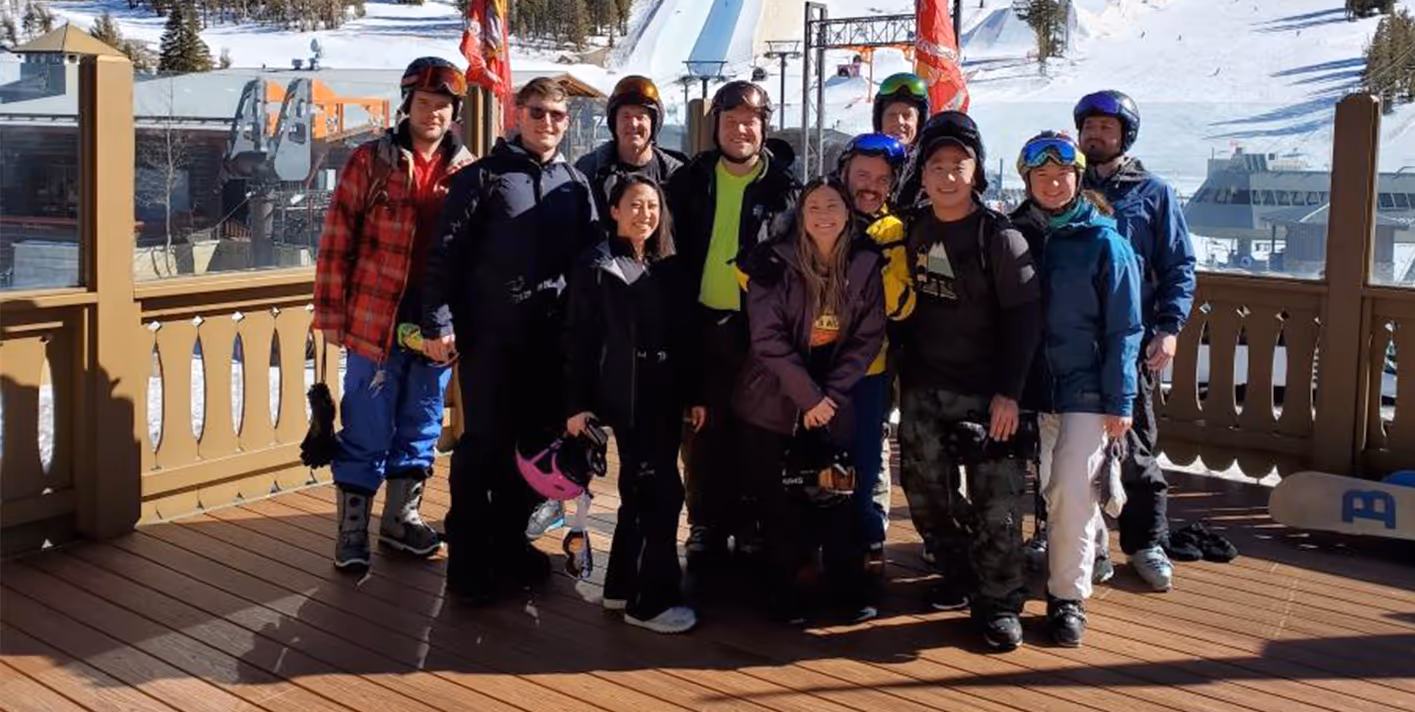 A group of people standing on a wooden deck.