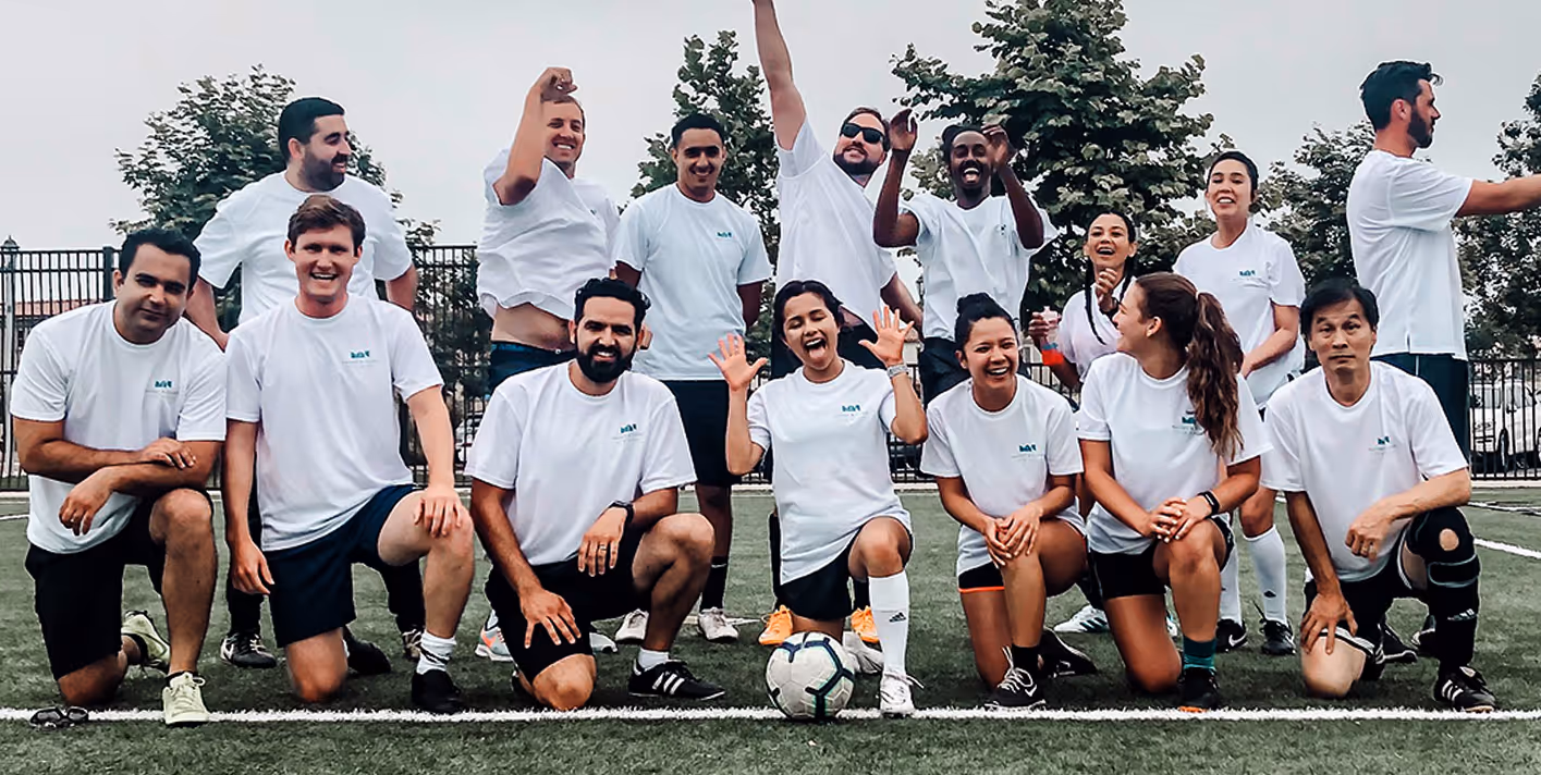 A group of people posing for a picture on a field.