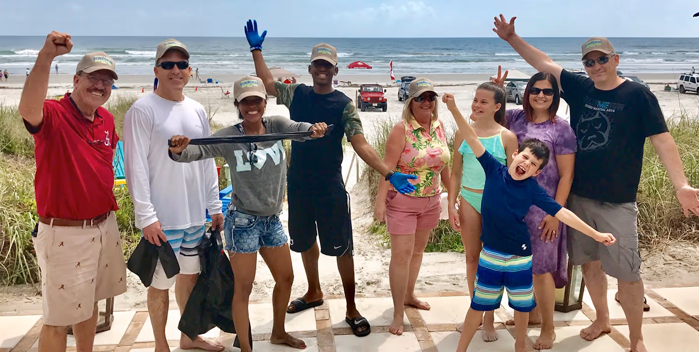 A group of people posing for a picture on a boardwalk.
