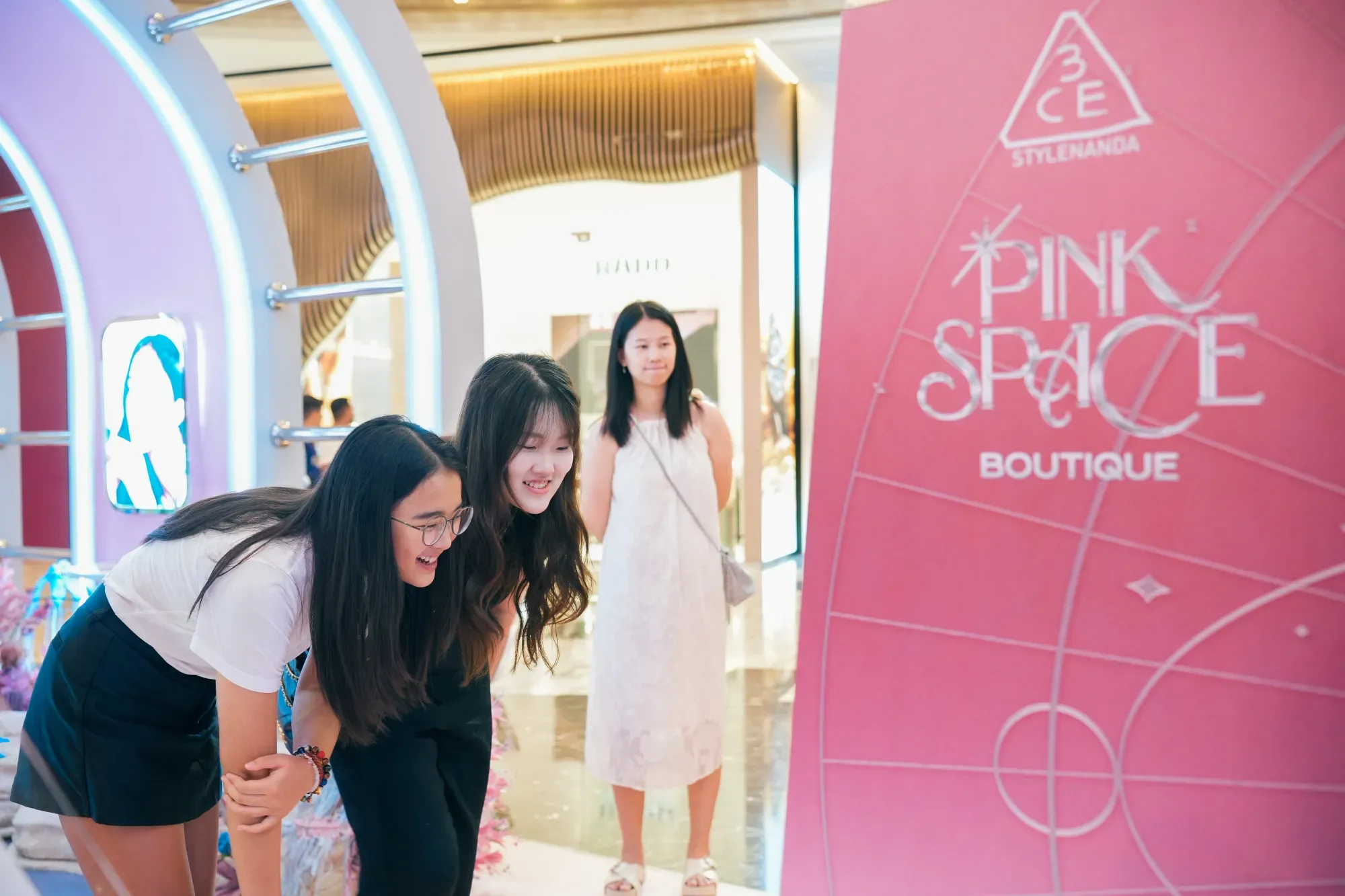 Guests using the 3CE Pink Space AI photo booth at a store launch, built by Instamedia