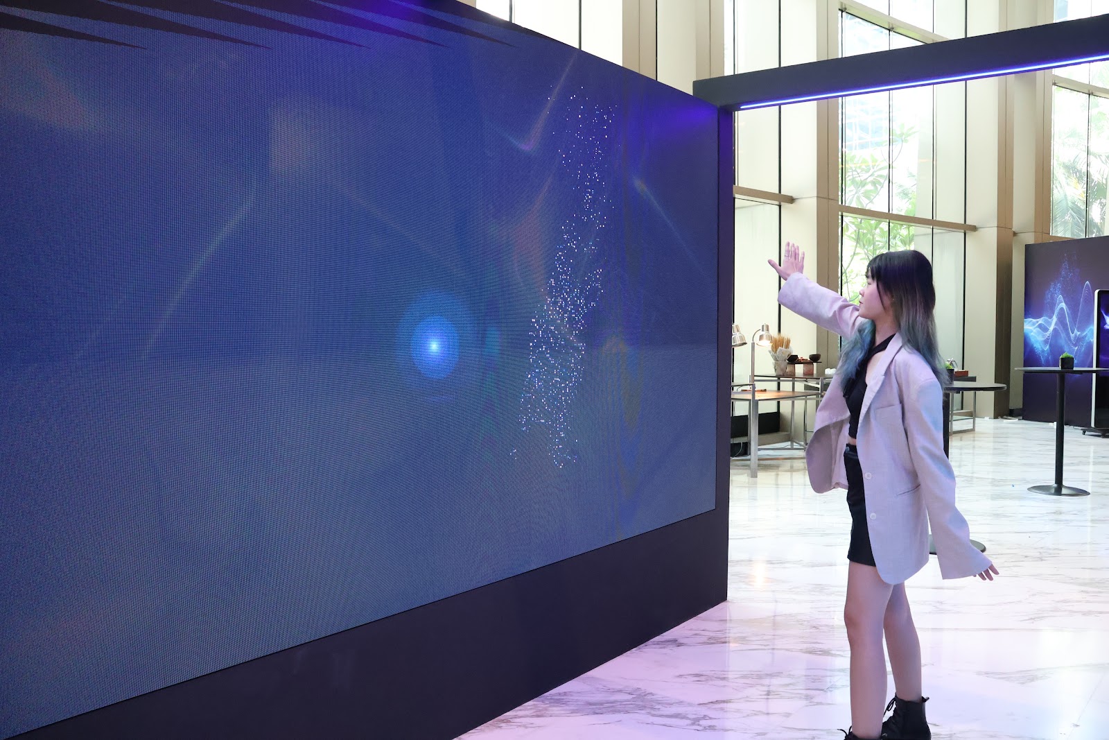 Body tracking particle effects reacting to visitors on an interactive LED wall in Malaysia
