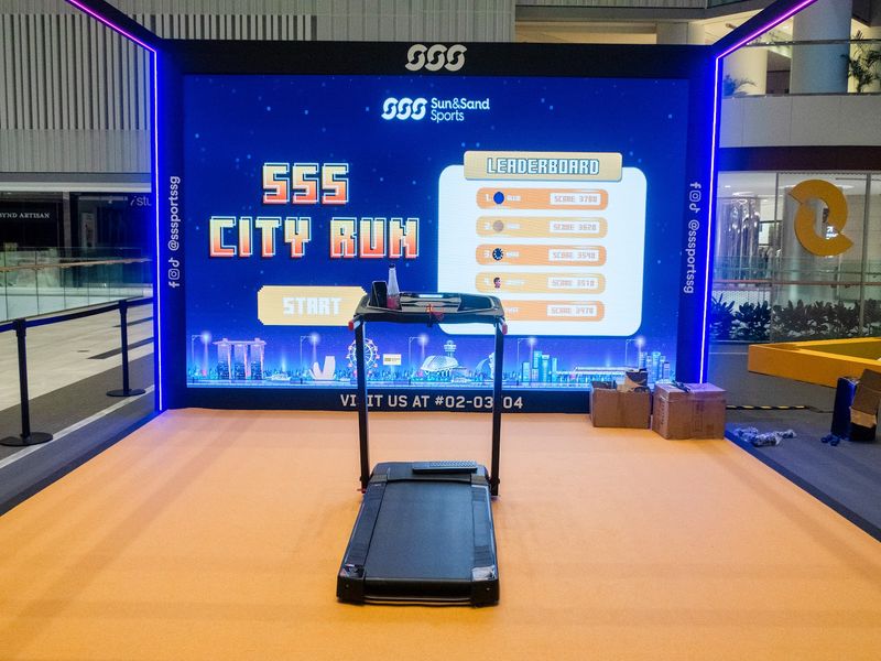 Branded treadmill game with a live leaderboard on an LED wall at a retail activation