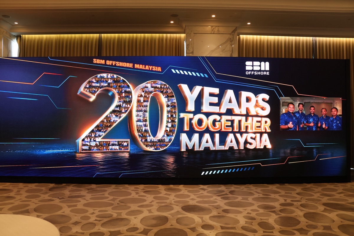 Live photo mosaic wall where guest photos tile into anniversary artwork on a wide LED screen