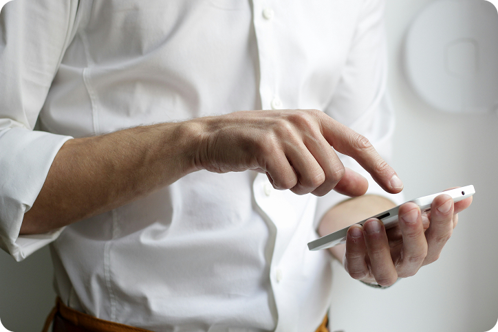 A man in a white shirt using a smartphone, representing a customer researching loans like LendingPoint.