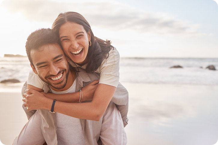 A happy couple laughing at the beach, representing customers comparing Sunbit vs Affirm payment plans.