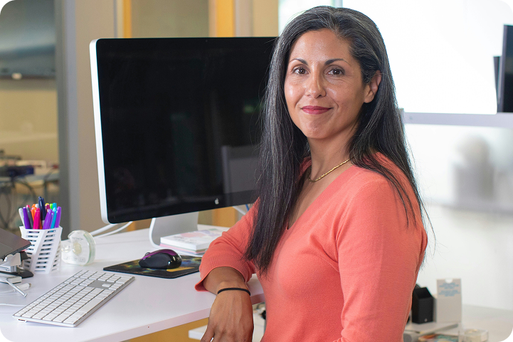 A professional woman sits at her desk in a medical office, representing a provider using med spa software.