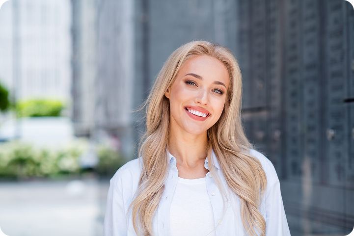 A smiling woman outdoors represents a customer exploring consumer financing options for healthcare payments.