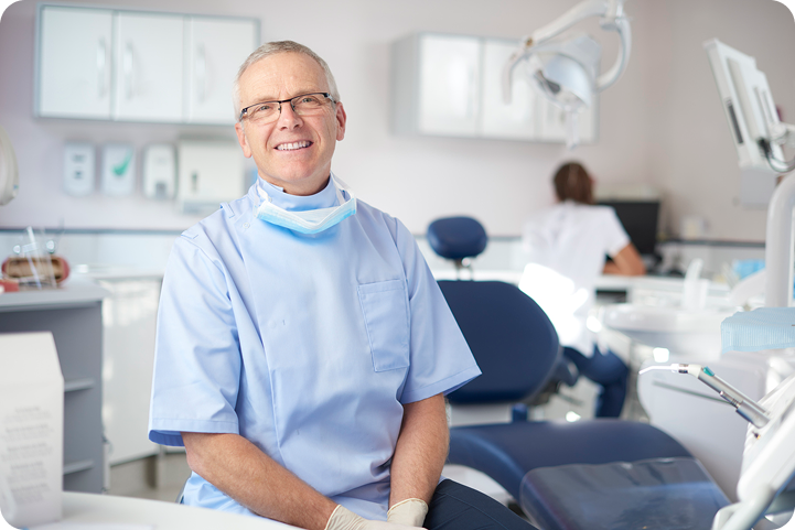 A smiling dentist sits in a modern exam room, representing providers offering a medical line of credit for patient payments.