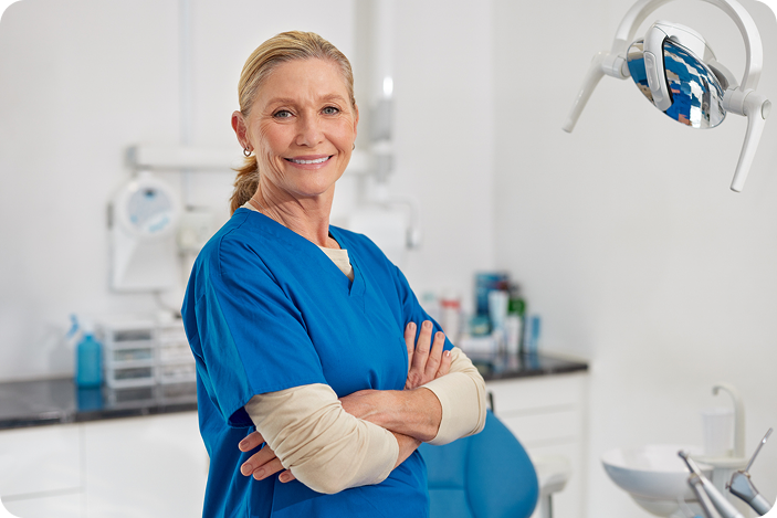 A confident healthcare provider stands in a dental office, representing in-house financing options for patient care.