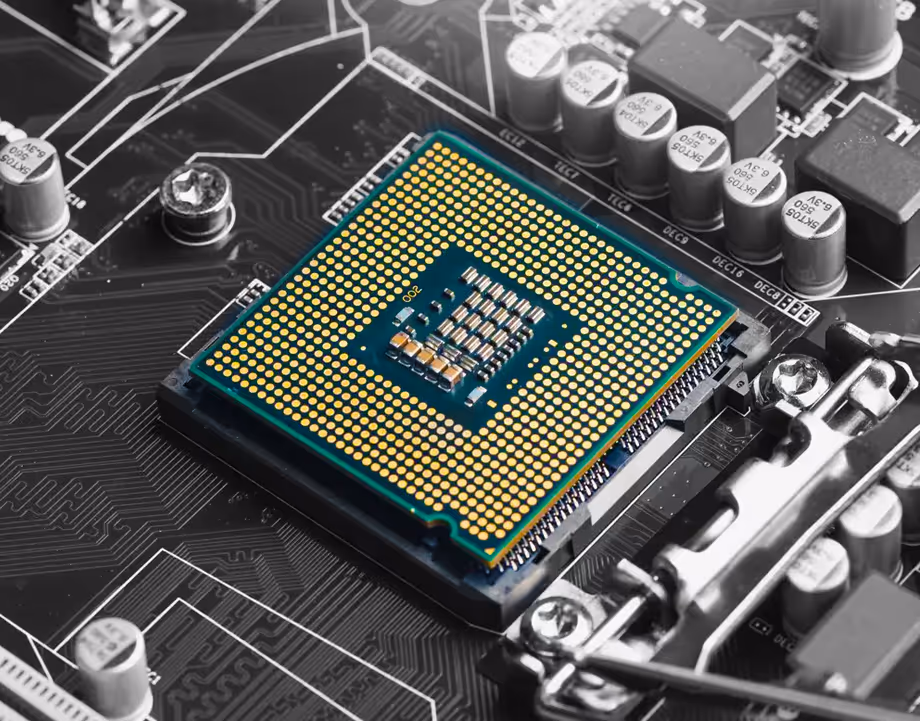 Close-up of a CPU chip installed on a motherboard with visible gold contact points and surrounding electronic components.