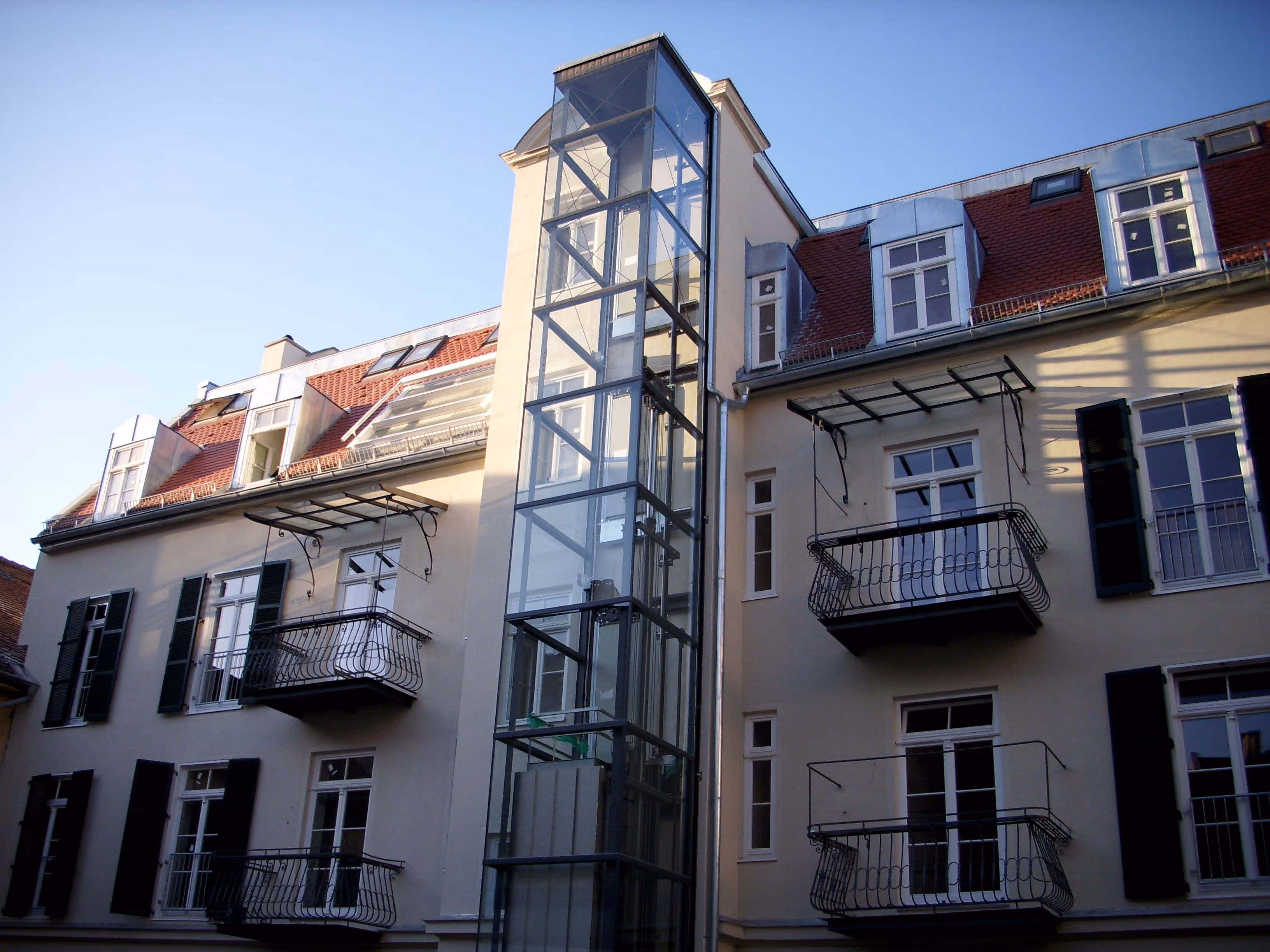 Renovierte Altbaufassade mit Aufzugsschacht außen