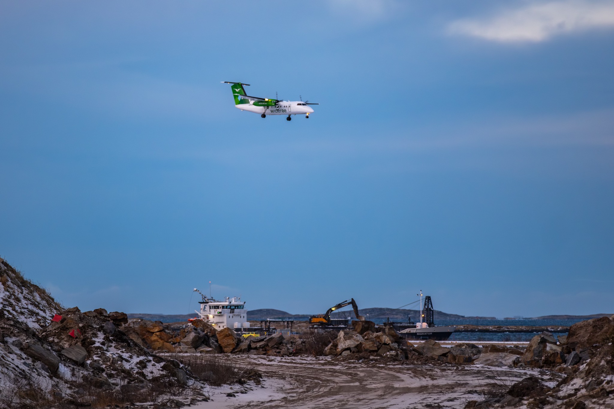 A cool picture showing Rignator 
anchored beside Bodø-Airport. Above the vessel you can spot a small widerøe plain flying over.