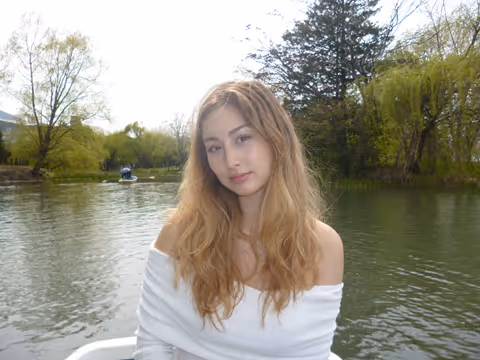 A student on a lake, she's staring at the camera.