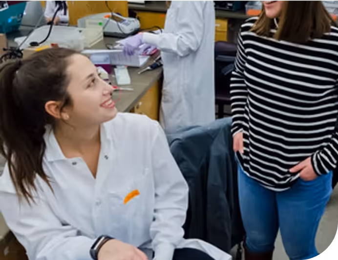 Two people smile in a lab setting.