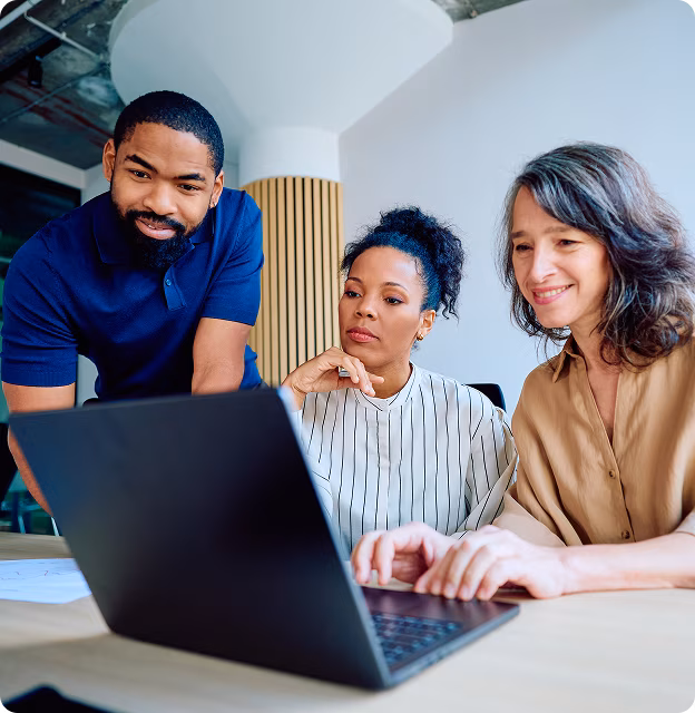 3 people looking over at the same laptop wondering how they are so far ahead of work with Facil-it