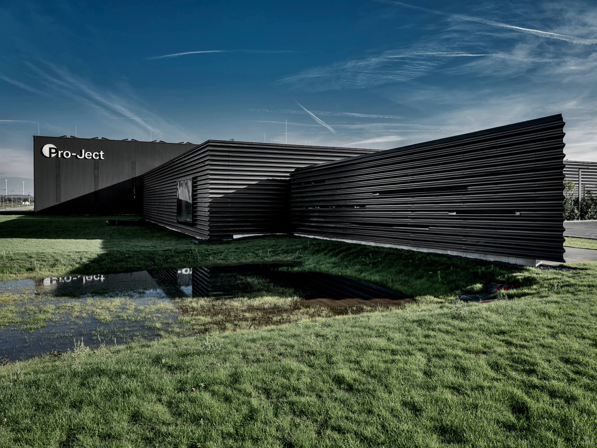 schwärzliches Blockhaus im futuristischen Design auf Grünfläche