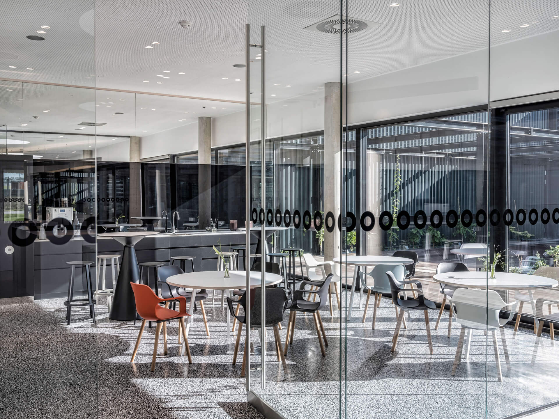 Pro-Ject Bürokantine mit weißen Tischen und bunten Sesseln