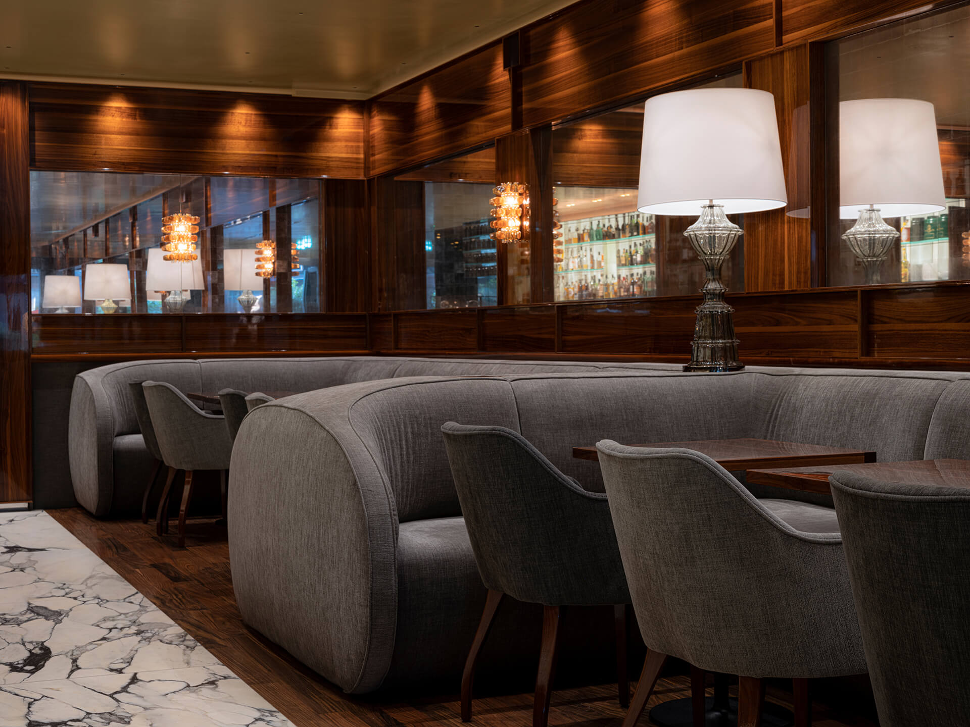 Fabios gräuliche Sofas neben Sesseln an Tischen