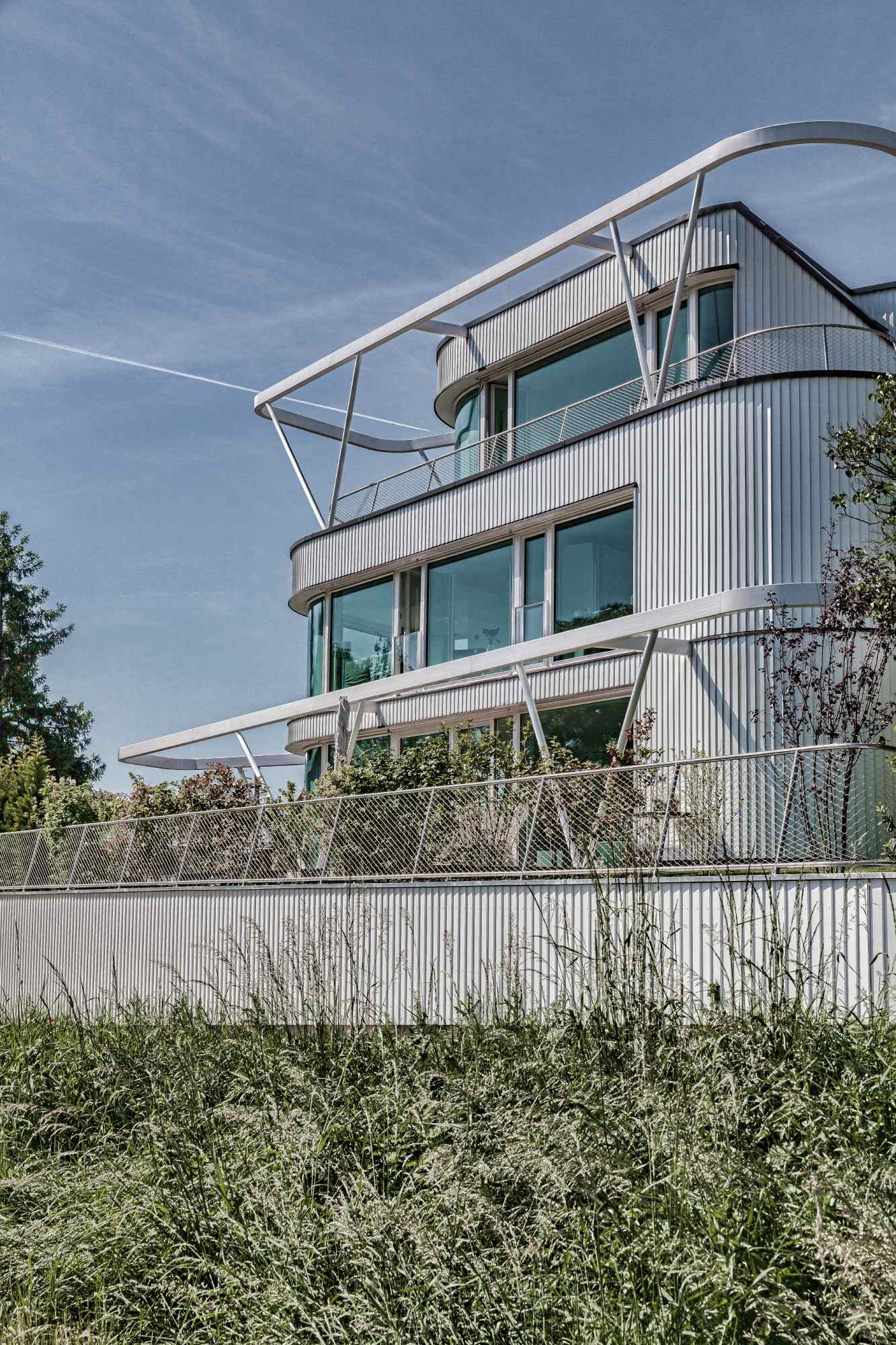 Seitliche Perspektive mit Fokus auf vertikale Glasflächen und Dachstruktur.